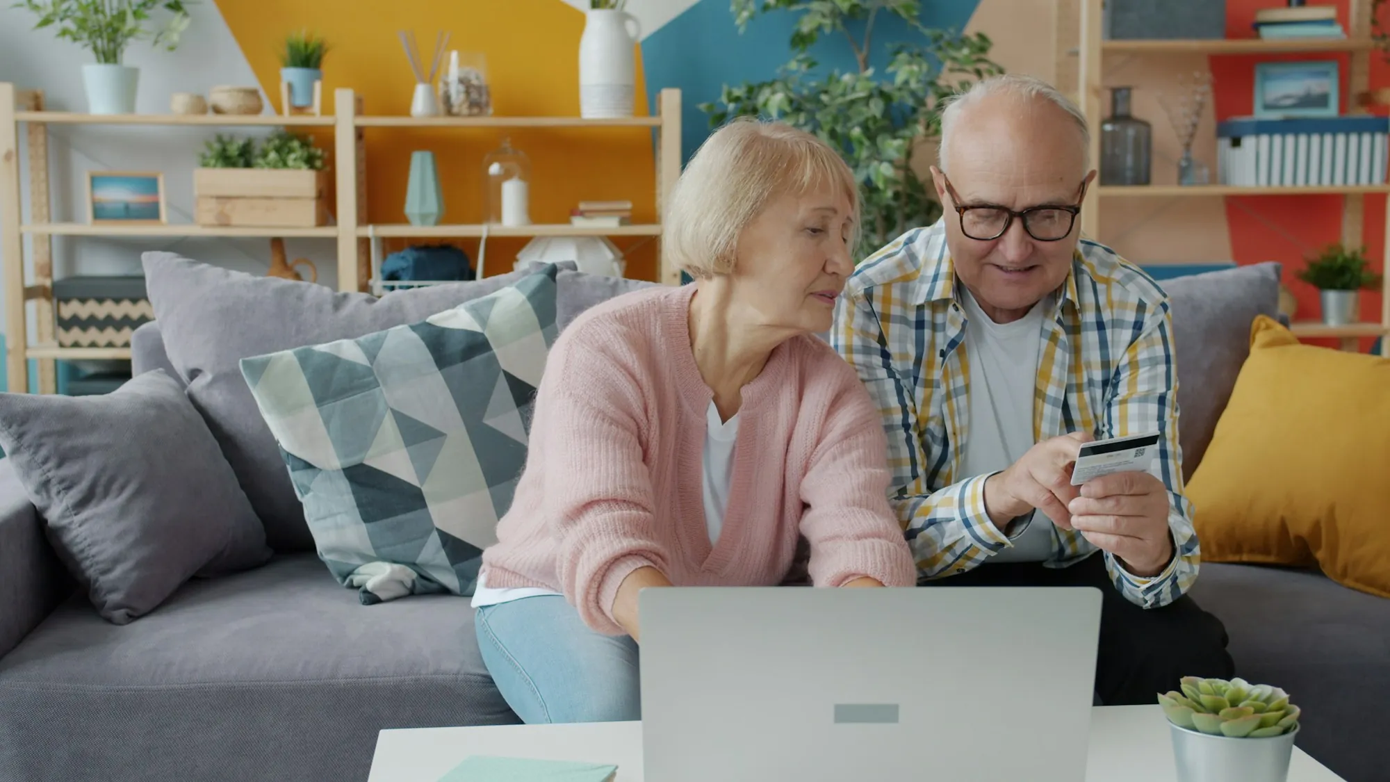 Older couple looking at a laptop together on the sofa