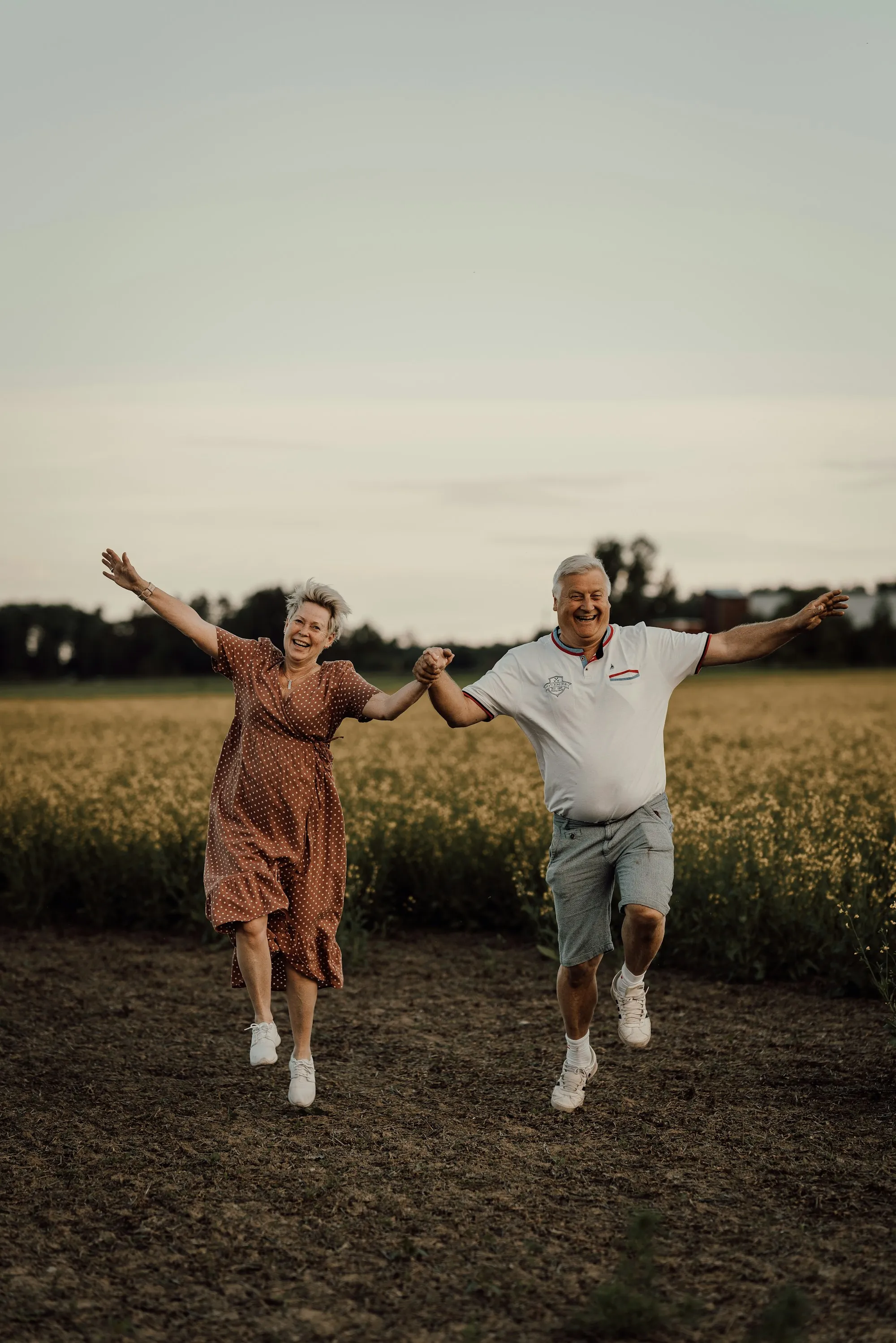 Older couple dancing joyfully in a field
